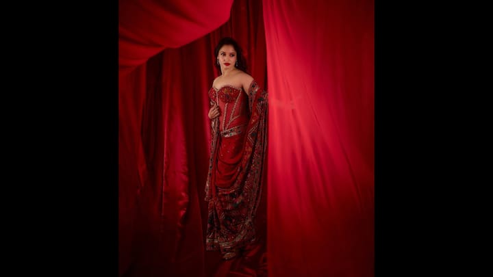 4. Tamannaah Bhatia: Tamannaah Bhatia gave her saree a modern twist by blending traditional elegance with contemporary flair. The actress wore a striking red saree that was crafted from luxurious crepe silk. The saree had delicate sequined embroidery and floral motifs. She paired it with a strapless corset blouse that featured net detailing and intricate embellishments. To complete her look, Tamannaah chose red drop earrings, green stone bracelet, and matching heels. (Image Source: Instagram/@tamannaahspeaks)