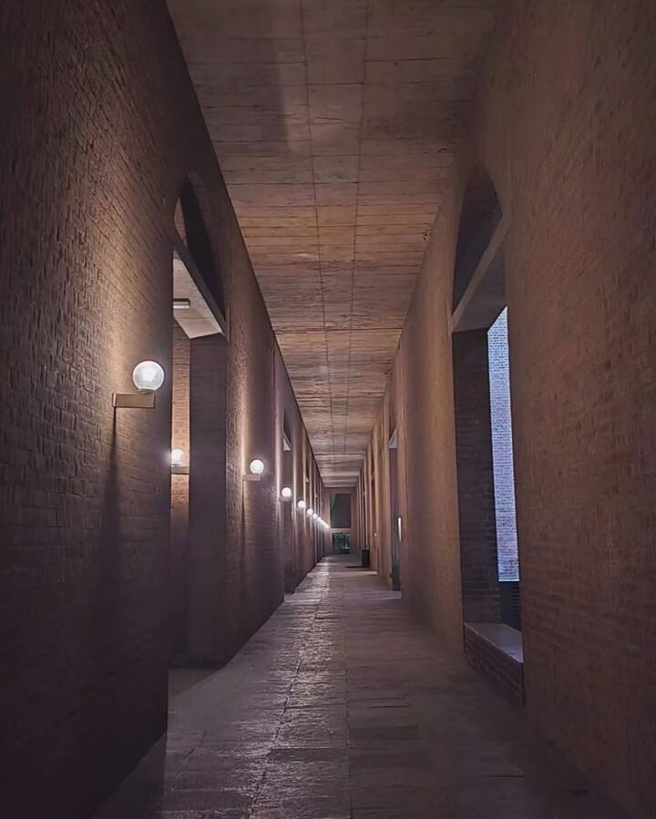 The architectural beauty of the campus adds to the aesthetic, with the red-brick walls and minimal lighting creating a serene mood.