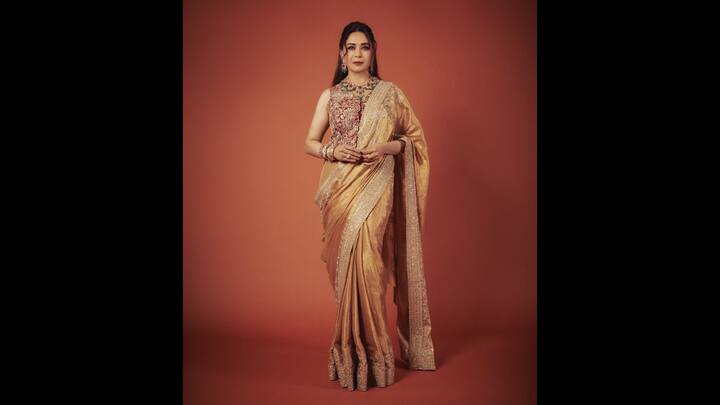 4. Regal Golden Saree: Madhuri Dixit wore a luxurious golden saree which was adorned with shimmering embellishments. She paired her regal saree with an embroidered maroon blouse which gave a statement look. Madhuri accessorised her look with statement gold jewellery that made her look poise and elegant. (Image Source: Instagram/@madhuridixitnene)