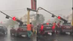नोएडा में तेज आंधी के बाद बारिश, DM चौराहे पर गाड़ी के ऊपर गिरा ट्रैफिक लाइट का खंभा