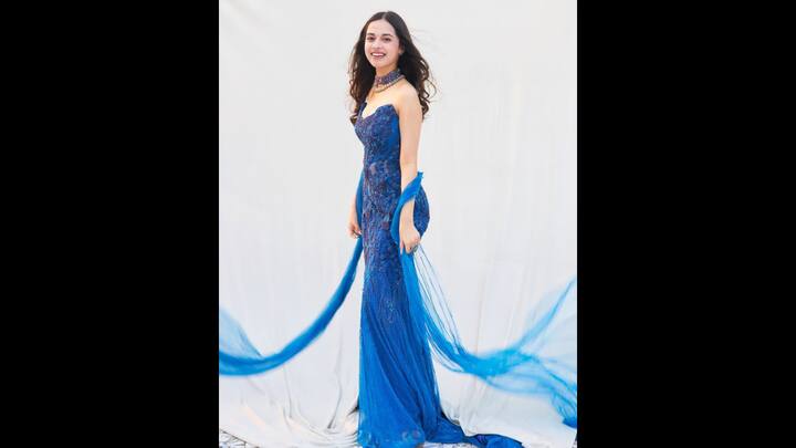 7. Shimmery Blue Embellished Gown: Nitanshi Goel looked enchanting her her regal blue gown. The strapless attire had a body-hugging design with intricate beadwork and sequins that created a beautiful look. The gown flared at the hem and gave a touch of classic elegance. To add drama to her attire, the actress added a flowing sheer drape that created an ethereal charm. To complete her look, she added statement jewellery pieces that made the ensemble a show-stopping choice for any occasion. (Image Source: Instagram/@nitanshigoelofficial)