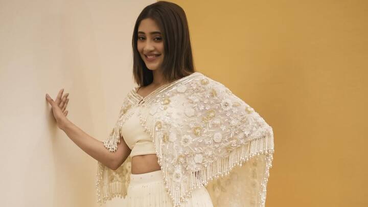 Shivangi reimagines elegance in this white lehenga adorned with an embroidered shrug. With subtle makeup and a streamlined silhouette, the look seamlessly merges old-world charm with contemporary poise. (Image Source: Instagram/ shivangijoshi18)