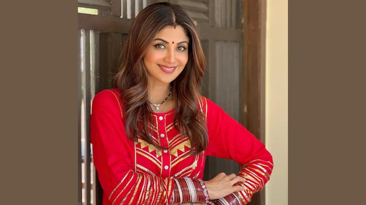 Shilpa Shetty exuded the bridal beauty in her red outfit decorated with Chola, Mangalstra and Sindoor. This look is a sentimental homage to married bliss and makes it a suitable option for married women who follow VRAT. (Image source: Instagram/Theshilpashetty)