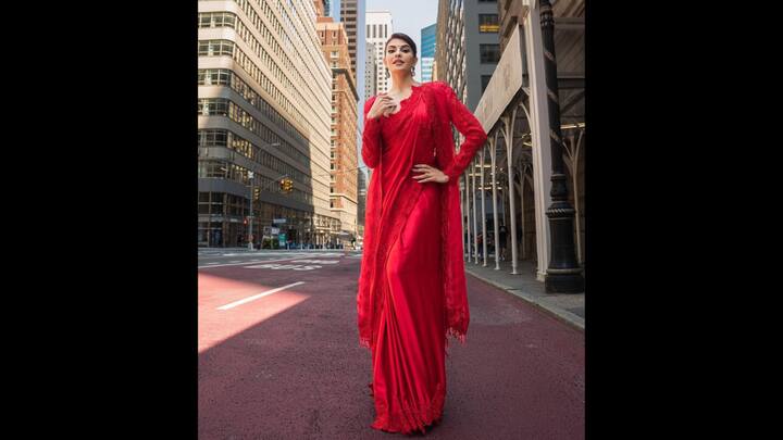 8. Statement Red Saree: The bold, monochrome saree worn by Jacqueline Fernandez was crafted with luxurious fabric. Her outfit was enhanced with delicate lace detailing at the borders and pallu for a subtle edge. The red full-sleeved blouse and the long jacket added drama to her traditional look. She completed her look with statement earrings which added sophistication to the ensemble. (Image Source: Instagram/@jacquelienefernandez)