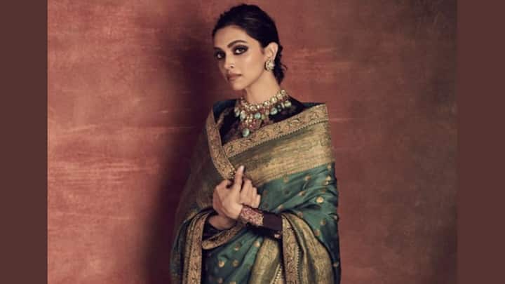 Deepika Padukone stood poised and dignified in this green saree paired with a black floral full-sleeved blouse. Her jewellery was minimalistic, and a timeless drape that suited the puja morning; elegance was in abundance. (Image Source: Pinterest/ Disha3012)