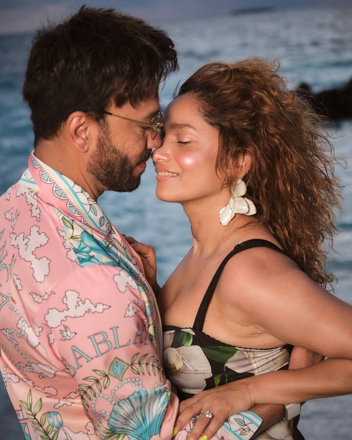Her statement floral earrings, which elevate her entire look with a breezy, coastal charm. Ankita’s glow-from-within makeup complements the golden hour lighting perfectly—her dewy skin, soft rose-toned blush, and a subtle nude gloss add to the dreamy aesthetic.