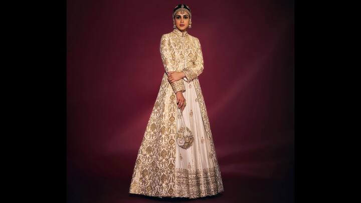 3. Ivory Anarkali Look: Genelia D'Souza adorned a stunning ivory and gold floor length voluminous Anarkali. Her ensemble had golden embroidery all over it that enhanced the opulence of the look. She paired her look with a matching potli bag for a show-stopping look. To add glamour to her traditional outfit, Genelia added exquisite heritage jewellery which included a matha patti and jhumkas for a majestic and royal touch. (Image Source: Instagram/@geneliad)