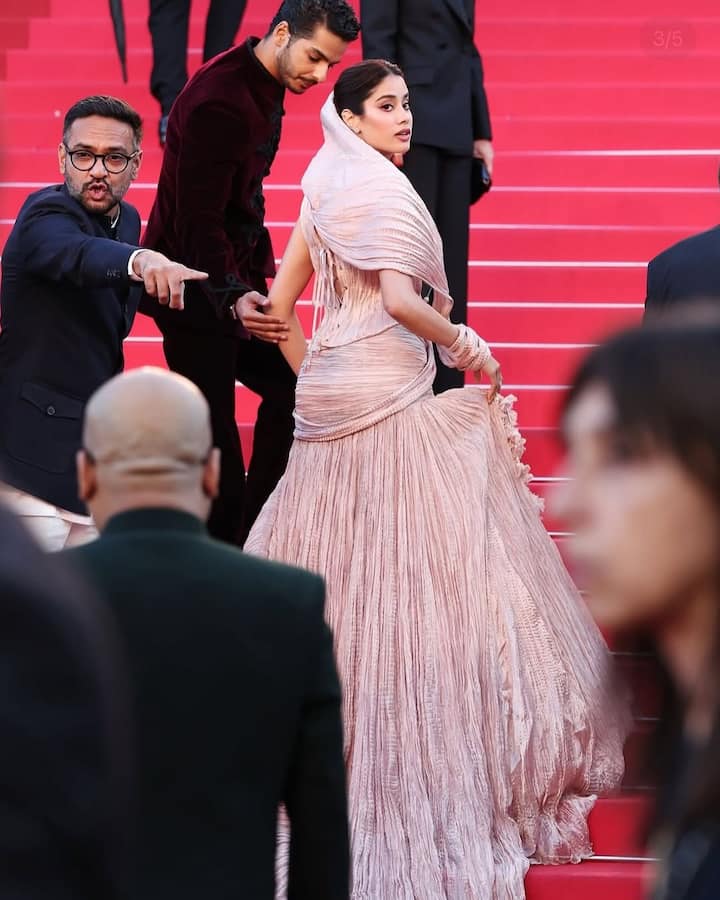 रेड कार्पेट पर जाह्नवी को उनकी ड्रेस के साथ ईशान और डायरेक्ट नीरज हेल्प करते हुए नजर आए. उनका लुक वायरल हो रहा है.