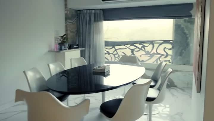 White creamy color is visible inside the house and on the walls. There is a stylish dining with a white chair and black table, where the actress also enjoys the nature while eating food.