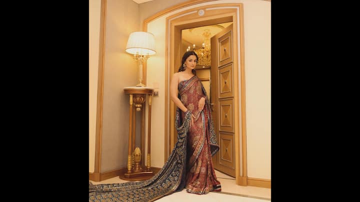 2. Regal Saree Moment: Alia Bhatt draped a traditional and intricately woven Banarasi saree. She opted for a strapless blouse that added a modern touch to her look. The actress beautifully created the perfect fusion of heritage and contemporary elegance. The saree featured rich maroon and navy hues and was adorned with delicate gold zari work and traditional motifs. She chose big statement earrings for a refined and graceful look. (Image Source: Twitter/@stayy4him)