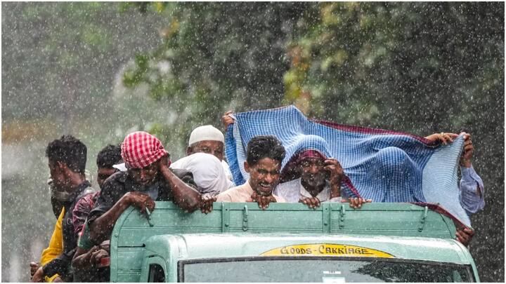 People use a scarf to shield themselves during rain in Kolkata. (Source: PTI)