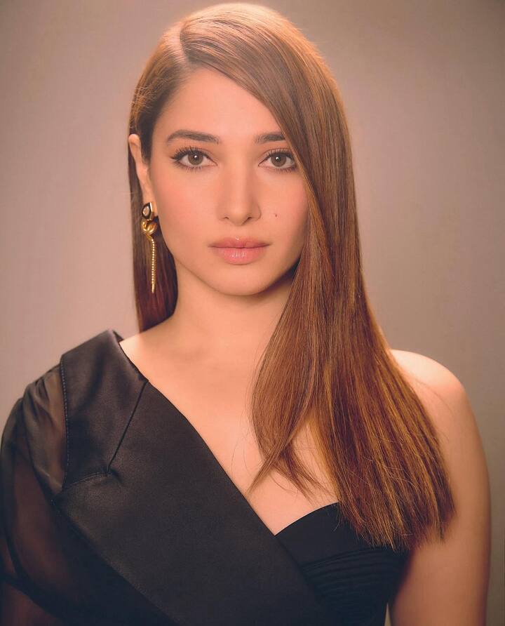An Eye-Catchy Statement Jewellery: Tamannaah looked ethereal in a black dress, paired it with dangly gold and black earrings featuring a unique hook-nail design, paired with rose gold rings—creating an angelic, bold-yet-elegant jewellery statement.