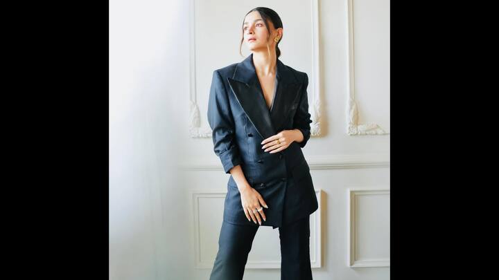 1. Alia Bhatt: Alia Bhatt's monochrome power suit look exuded sophistication. The actress was dresses in a black double-breasted blazed with pinstripes satin lapels. The longline blazer added a touch of boldness which she paired with tailored pants. She opted for a sleek hairstyle which gave her a minimalistic look. Alia wore statement rings and minimal earrings for a glamorous appeal. She served a poise and undeniably stylish look with her effortlessly chic attire. (Image Source: Instagram/@aliaabhatt)