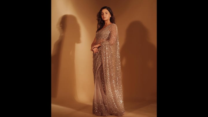 3. Sheer Sequin Saree: Alia Bhatt wore a sheer and elegant saree that brought radiant charm to frame. The soft fabric had a subtle yet striking sequin work that added an ethereal look to the actress. The delicate saree was adorned with shimmer, making the actress look gorgeous, while blending contemporary grace with tradition. She opted for minimal earrings and statement rings to enhance her fit. (Image Source: Instagram/@aliaabhatt)