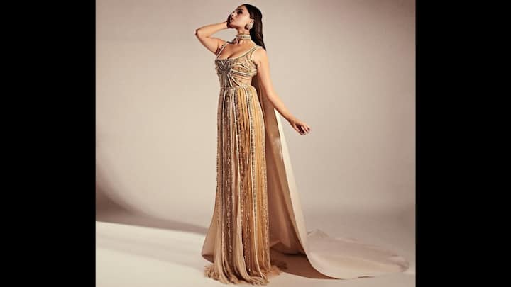 8. Golden Gown: Alia Bhatt wore an exquisite golden gown that had a vintage allure. The modern fit filled with opulence was heavily embellished with intricate beadwork and sequins. The delicate straps and structured bodice enhanced the aesthetic which the dramatic cape added flair. To elevate her regal attire, the Bollywood actress opted for statement matching jewellery that channeled goddess energy. (Image Source: Instagram/@aliaabhatt)