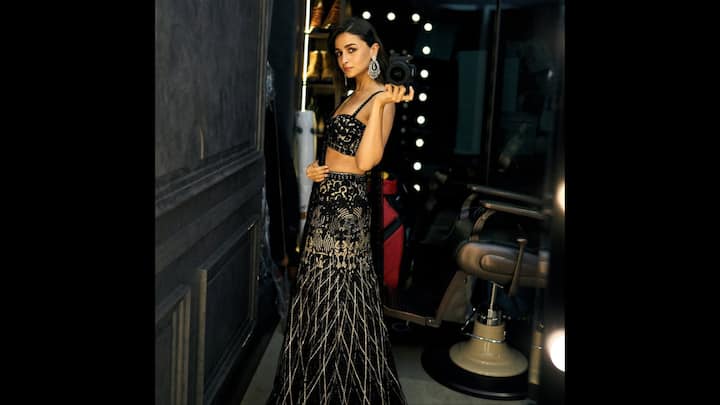 7. Glamorous Lehenga: The black and gold lehenga worn by Alia Bhatt exuded a contemporary charm. The ensemble featured sequin work and intricate embroidery with a modern silhouette. The detailed design, structured fit, and sleeveless blouse added a regal touch to the actress. She paired her traditional outfit with statement earrings that made the outfit luxurious. The fit featured the perfect balance of glamour and elegance. (Image Source: Instagram/@aliaabhatt)