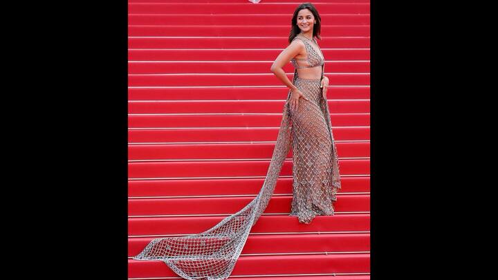1. Sheer Gucci Outfit: Alia Bhatt made a stunning statement at the Cannes 2025 red carpet where she dazzled in a sheer outfit by Gucci. The Bollywood star walked in a sheer, shimmering silver netted ensemble that featured intricate crystal embellishments over a nude base. The plunging neckline and floor-length train gave a sophisticate look. Radiant and poised, the actress accessorised her fit with minimal accessories, allowing the outfit to be the focal point. (Image Source: Instagram/@aliaabhatt)