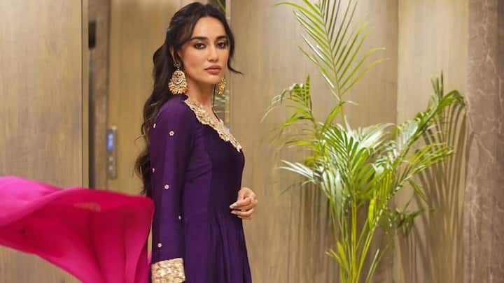 Surbhi Jyoti looked elegant in this majestic purple kurta set featuring delicate gold embroidery on the neckline, sleeves, and cut-work hem. Paired with this contrasting pink dupatta and show-stopping gold jewellery, this look exuded elegance and glamour. (Image Source: Instagram/ surbhijyoti)