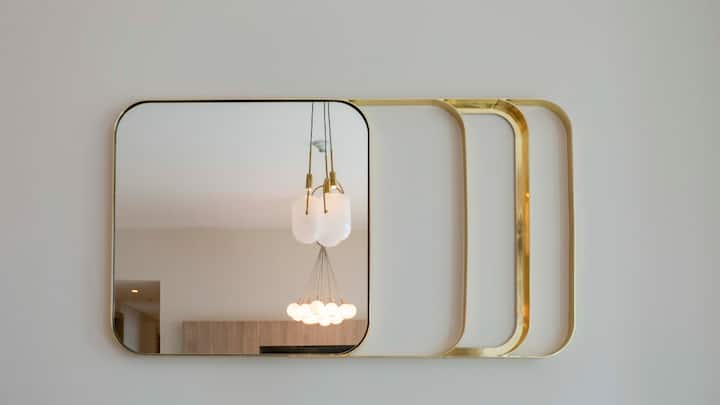 Mirrors That Expand Space: Mirrors can additionally be used to create an illusion of space when set up in certain places. If a large mirror is placed against a wall facing a window, it can enhance the brightness of the room and make it look more spacious. (Image Source: Canva)