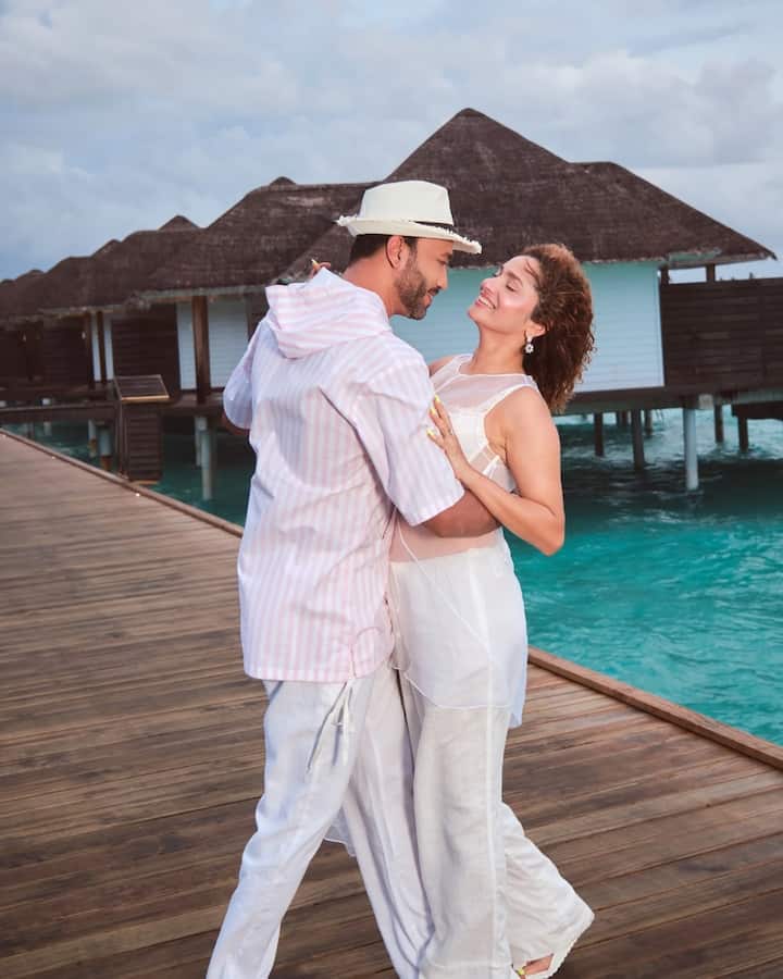 He tops off his look with a beige hat, adding a dash of classic resort style.