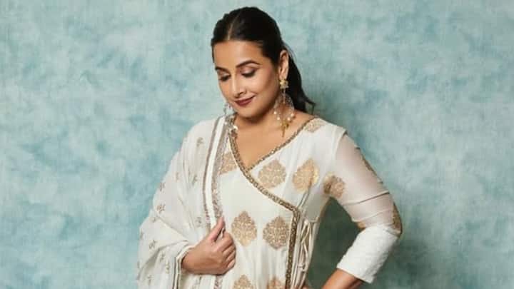 Vidya Balan channels tradition in this golden-white Anarkali with an Angrakha silhouette. Featuring delicate gold borders and minimal makeup, her look, paired with statement earrings, is pure festive royalty. (Image Source: Instagram/ balanvidya)