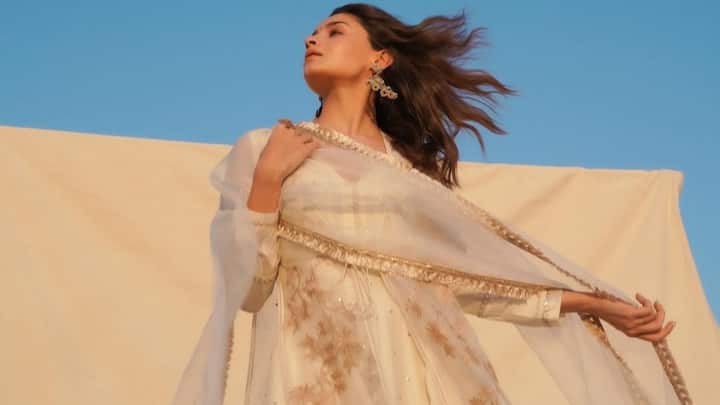 Alia Bhatt offers modern-day elegance in this white Anarkali with a dramatic plunging sweetheart neckline and sheer sleeves. Gold sequin embroidery and organza overlay give the perfect fusion of celebration and freshness for Bakrid. (Image Source:  Instagram/ aliaabhatt)