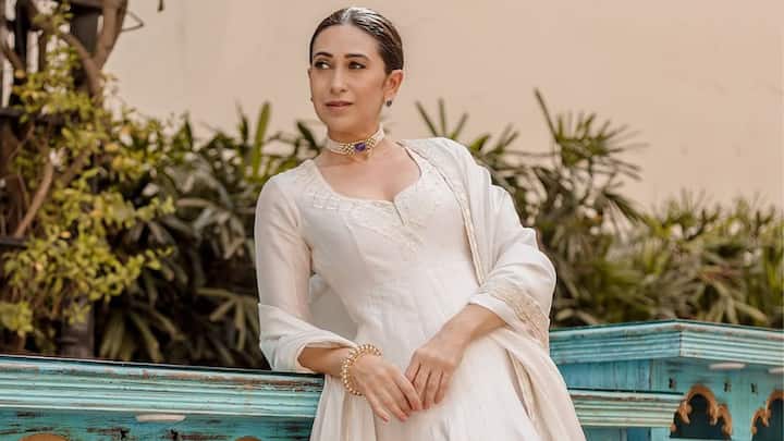 Karisma Kapoor's Chanderi white silk Anarkali, which is elaborately embroidered with coin embroidery and paired with a matching churidar and organza dupatta, is an impeccable choice for Bakrid. Her pearl choker and low bun provide the regal touch. (Image Source: Instagram/ punitbalanaofficial)