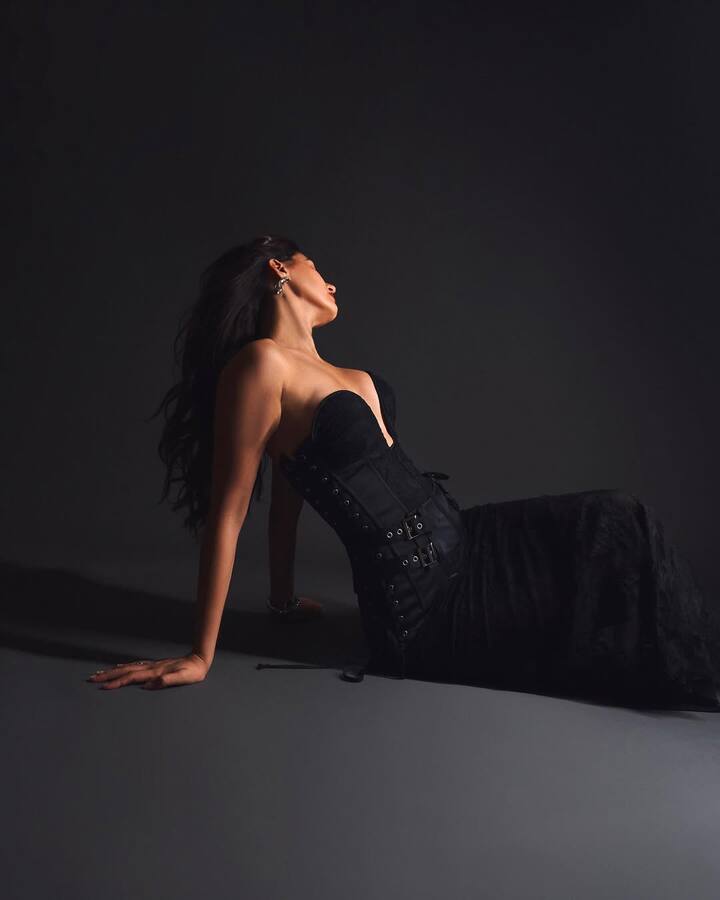 Disha stuns in a strapless black corset gown with a sharply sculpted neckline and cinched waist that accentuates her silhouette. The bodice features multiple belted details and lace panels, adding a gothic undertone to the otherwise classic shape. The look toes the line between boudoir and high fashion, turning the corset into a power statement rather than just a trend piece.