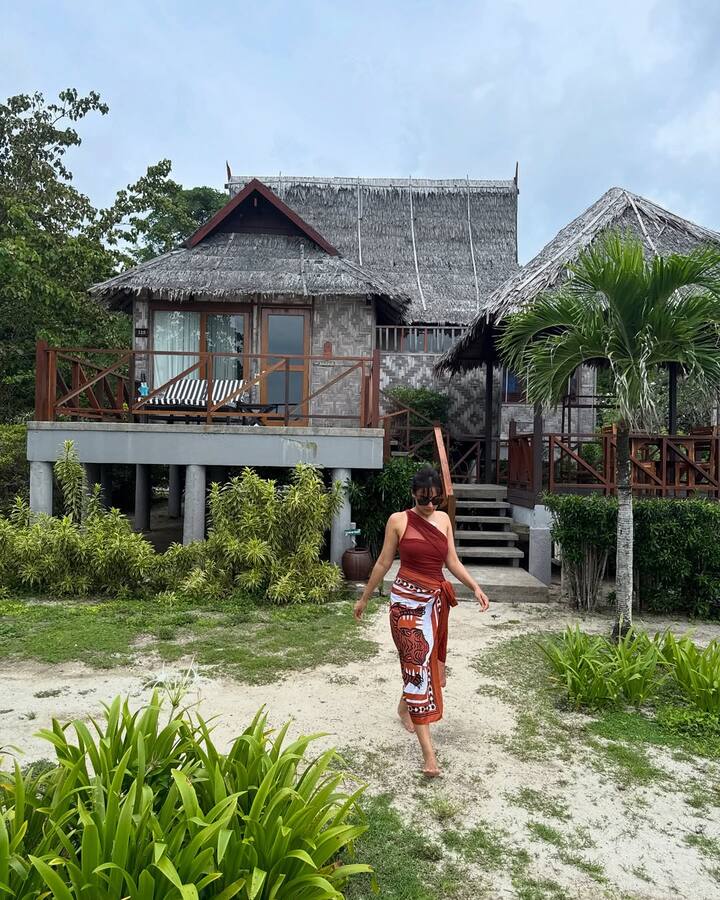 She styles it effortlessly with a tribal-printed sarong, knotted neatly at the waist for a chic beachside vibe.