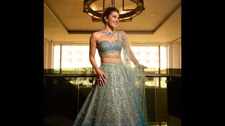 3. Priyanka Chopra: Priyanka Chopra wore an iconic pastel blue embellished lehenga. This look served as a show stopper, featuring floral embroidery and gradient shades of sapphire and aqua. She wore a one -shoulder sweetheart neck blouse which gave her a chic vibe. The actress paired her fit with a striking diamond and emerald necklace and minimal matching earrings. Her ethnic outfit screamed festive finesse and brilliance. (Image Source: Pinterest/bollywoodshaadis)