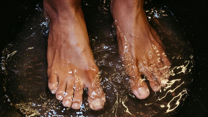 8. Try Cold Or Warm Foot Baths: Alternating between warm and cold foot baths can stimulate circulation and help relax your entire body. This is a simple and calming therapy that reduces the symptoms of headache, especially those related to stress and tension. (Image Source: Canva)