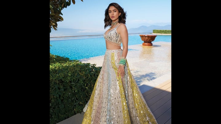 2. Mrunal Thakur: Mrunal Thakur radiated regal charm in her breathtaking mirror work lehenga set. Mrunal's look felt equal parts royal and refreshing. The multi-panel lehenga featured intricate mirror embroidery throughout, crafted in soft pastel hues like powder blue, blush pink, lemon yellow, and ivory. The fusion of colours added depth, movement, and elegance to her ensemble. The blouse with a daring neckline and heavily encrusted mirror work, gave the actress a luxe finish. Mrunal styled her ethnic fit with contrasting green bangles, a statement choker, and soft waves. (Image Source: Instagram/@gopivaiddesigns)