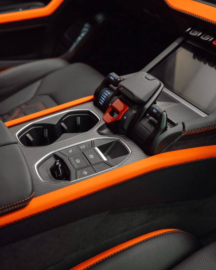 The car features a unique Verde Gea (matte olive green) finish with a black-and-orange leather interior.