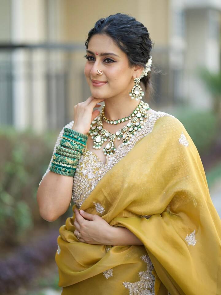 Stacks of green glass bangles add a pop of colour and a traditional flair, perfectly complementing the saree’s palette.