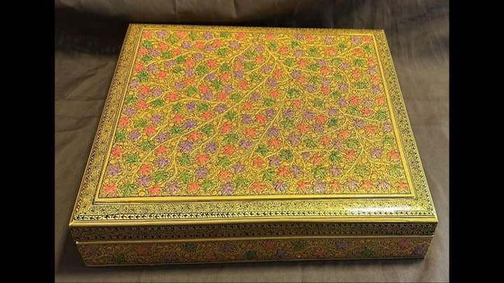 4. Papier Mache Box With Gold Leaf Work: This bright coloured box with touches of gold was gifted to Salma Lakhani, Lieutenant Governor of Alberta. This Papier Mache box from Jammu and Kashmir showcases the region's rich cultural legacy and craftsmanship. The creation involves 'sakhtsazi,' a process of moulding recycled paper into shape using layers of pulp, followed by sun-drying to harden it. The second stage, 'naqashi,' involves hand-painting the box with delicate motifs, from blooming flowers and vibrant birds to Chinar leaves and idyllic landscapes. (Image Source: Twitter/@ANI)