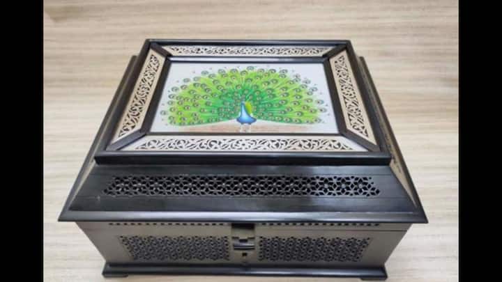 3. Ebony Wood Jali Work Box With Silver Nakkashi Work: PM Modi gifted Danielle Smith, Premier of Alberta, an Ebony Wood Jali Work Box with Silver Nakkashi Work during his visit to attend the G7 Summit. This elegant work of art is made from dark Indian ebony wood. This Rajasthani craft features detailed silver inlay work and a colourful hand-painted peacock on the lid. Inspired by famous Indian monuments, the box has been hand-carved using a traditional jali design. Nakkashi, the silver inlay, is an ancient craft where silver sheets are carefully shaped and added by hand. (Image Source: Twitter/@ANI)