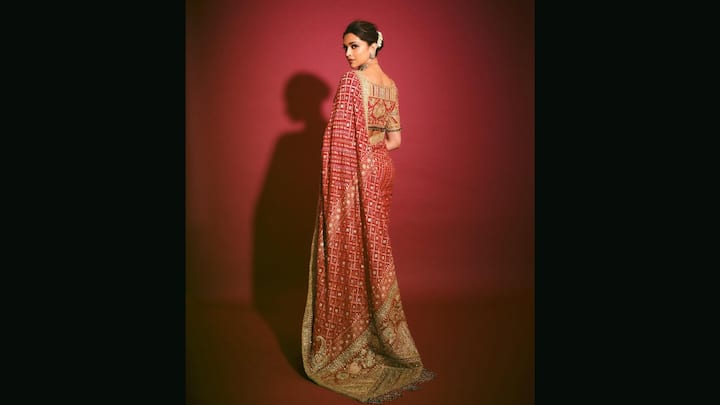 5. Deepika Padukone: Deepika Padukone exuded elegance in a red bandhani saree. Crafted using the intricate bandhej tie-dye technique, this saree showcased traditional motifs in a vivid red palette. What makes this Bandhani saree for weddings stand out is the rich zari and gota patti border, adorned with detailed paisley motifs and floral embroidery. The saree is paired with a regal, heavily embellished golden blouse featuring zardozi work. (Image Source: Instagram/@deepikapadukone)