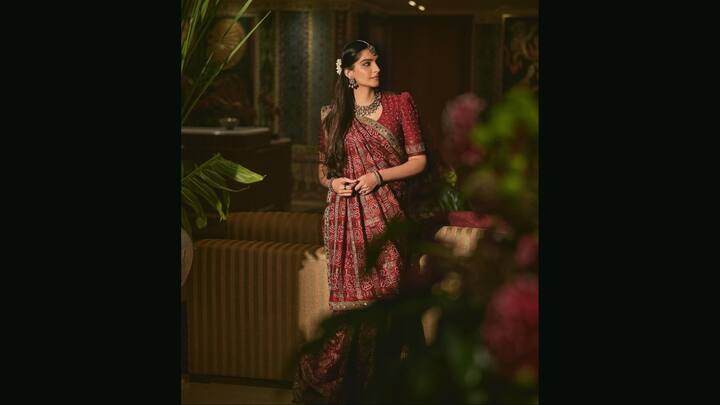3. Sonam Kapoor: Sonam Kapoor wore a bandhani Gharchola saree, a treasured heirloom that holds deep cultural significance in Gujarati weddings. Drenched in deep tones and adorned with bandhani patterns, this saree is a stunning example of Gujarati bandhani craftsmanship. The square check motifs filled with dots and animal symbols are classic hallmarks of the Gharchola weave. Sonam styled it with a vintage puff-sleeve blouse, temple jewellery, and a matha patti that reflected how Bandhani sarees for weddings can be royal and rooted. (Image Source: Instagram/@sonamkapoor)