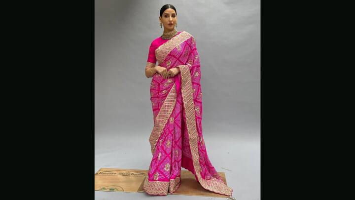 1. Nora Fatehi: Nora Fatehi looked flawless in a breathtaking rani pink bandhani saree. Draped in rich tradition and opulence, the saree showcased intricate morpur bandhani work, a traditional tie-dye technique. The vibrant rani pink base is adorned with classic white dot patterns and gold zari embroidery. Paired with a matching pink blouse and styled with regal jewellery, Nora embodied modern royalty. The broad golden border added grandeur, while the subtle motifs within each square reflected timeless craftsmanship. (Image Source: Instagram/@faabiianaindia)