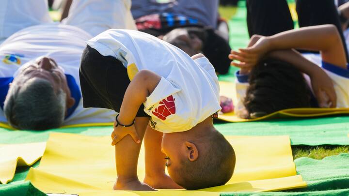A toddler performs yoga during a session organised on the International Day of Yoga, at the lawns of Kartavya Path in New Delhi. (Image Source: PTI Images)