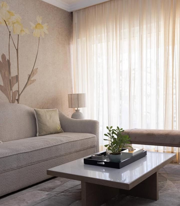 The actress's living room is a specialty. She told that she spends most of her time in the living room. Here a plant like a cindar is placed on the table and a sofa is placed. Here she spends most of her time because here is a big window from where fresh air comes and the actress gets relaxed here. This corner of the actress' house is also very beautiful.