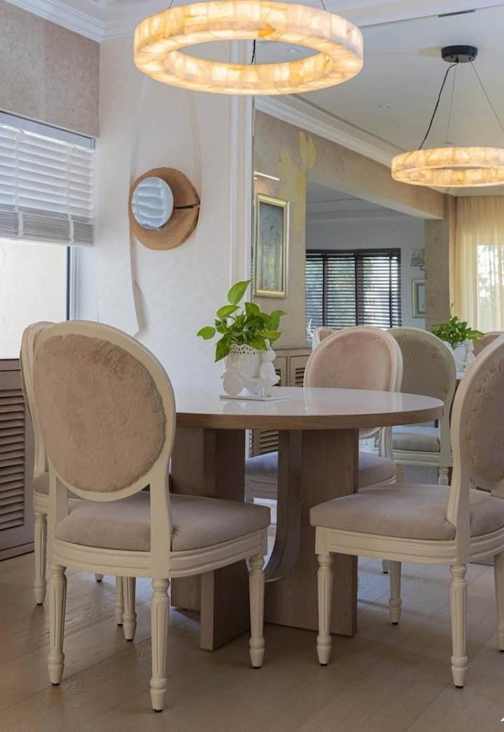 The dining space of his home is also quite beautiful and classy. Here Ananya hosts her guest. Here the chairs of pastel color are placed in front of a round table.