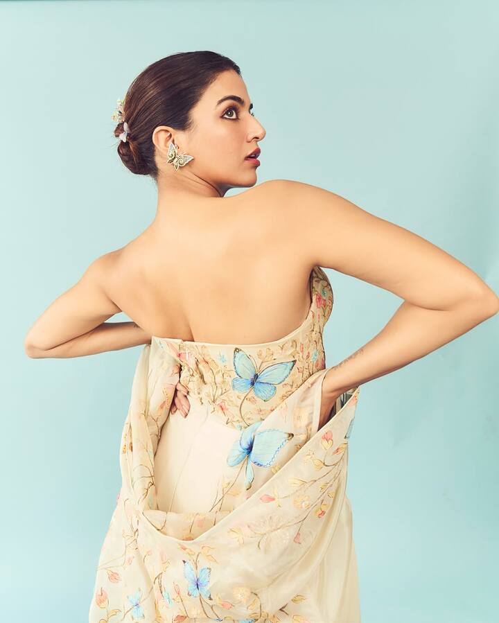 Wamiqa styled her hair in a sleek, low bun decorated with pastel floral pins—an ideal pairing with the dreamy, soft aesthetic of her attire. The bun not only showcased the large butterfly ear cuffs beautifully but also exuded a regal calmness.