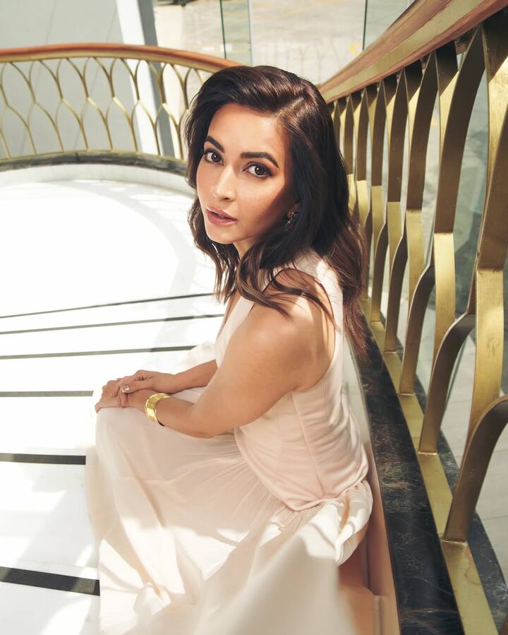 Kriti's hair is styled in soft, voluminous waves cascading gracefully over her shoulders, bringing in a romantic vibe that ties the whole look together.