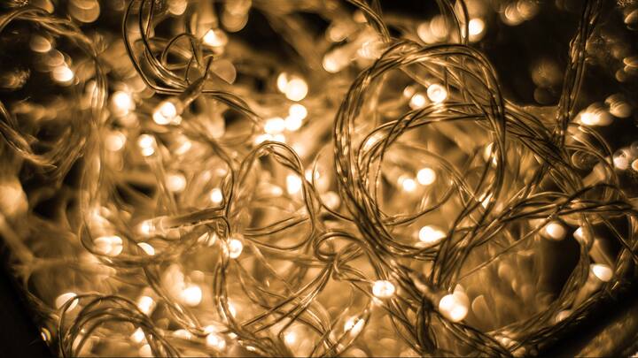 6. Introduce Cosy Lighting and Warm Colors: Grey rain clouds seem to drain colour from everything, including the rooms we live in. Warm LED lamps, tiny fairy strings, or soft night lights can change that. Add cheery cushions, light throws, or simple artwork in mustard yellow, burnt orange, or deep teal, and the space suddenly feels brighter. (Image Source: Canva)