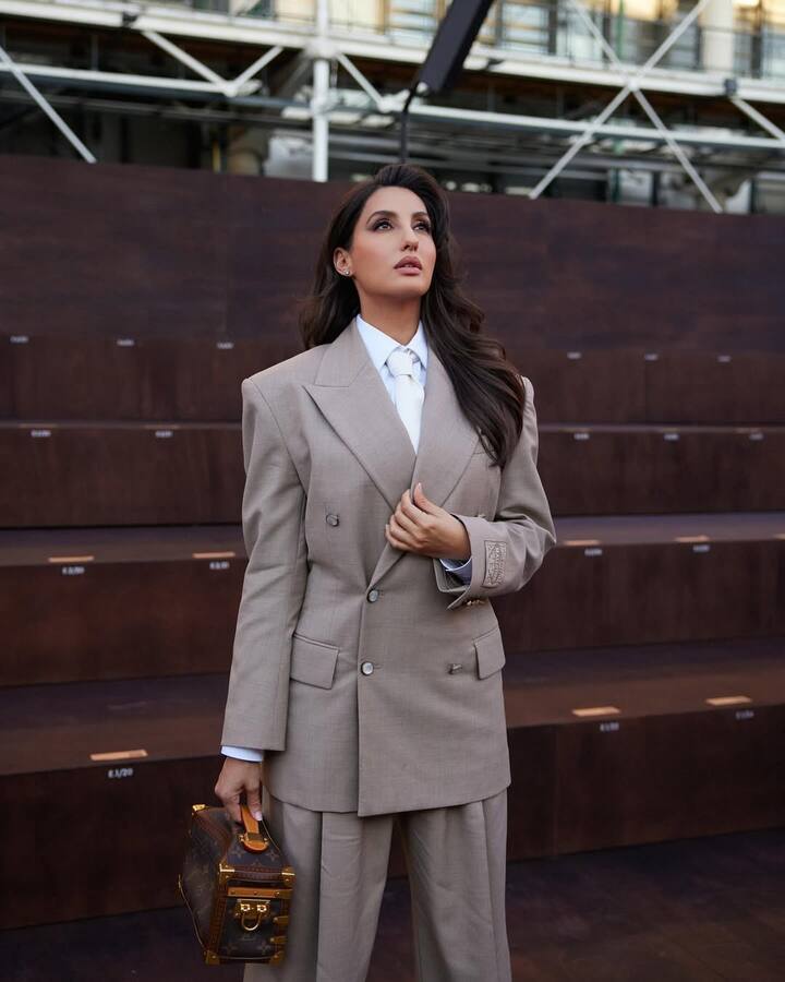 Nora’s styling was sharp and intentional. Her hair was styled into soft waves with side parting, adding a touch of feminine grace to her bossy look.