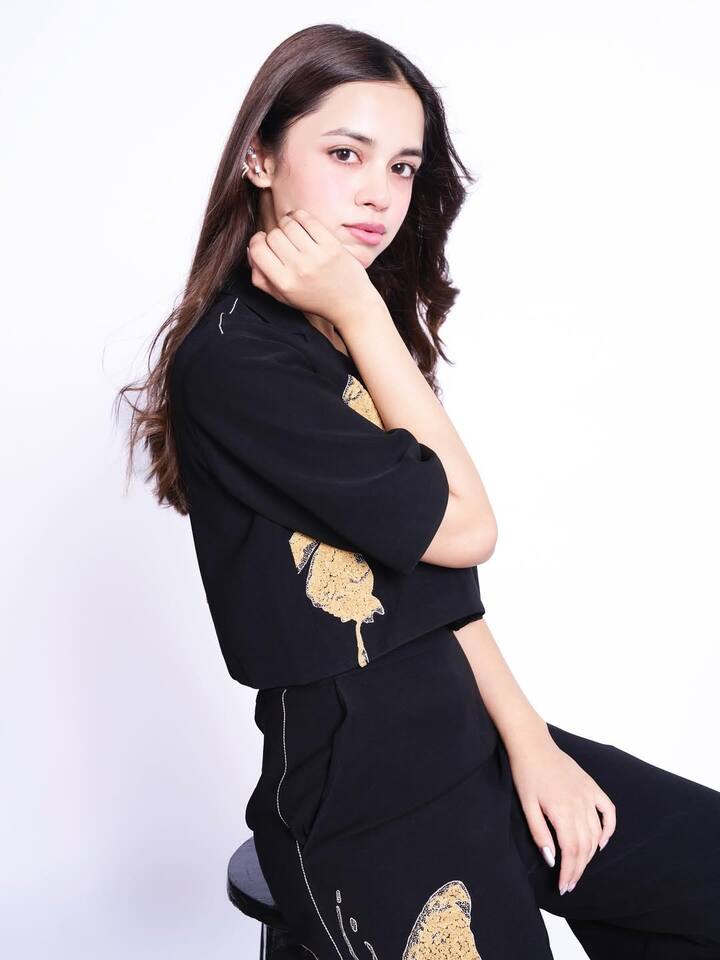 Nitanshi’s styling is just as impactful. She keeps her accessories minimal, letting the bold print and dramatic contrast of black and gold take center stage.