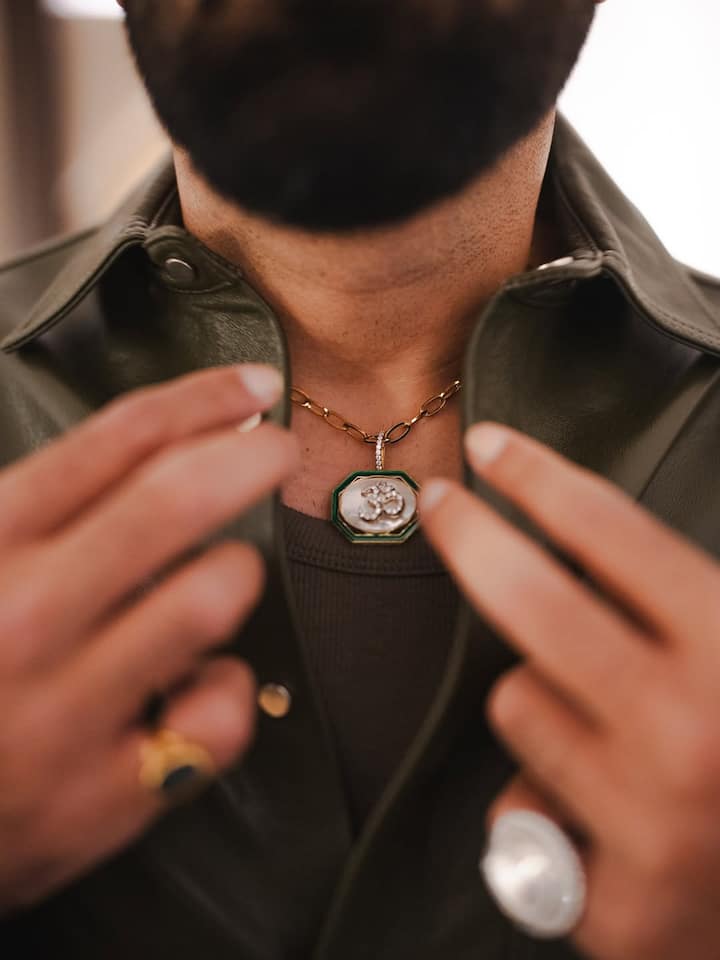 The 'Om' necklace in hexagonal shape, stooded with diamonds, took the center stage, paired with an interlocked gold chain.