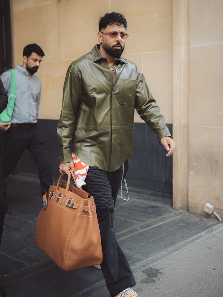 He further elevated the ensemble with a white and orange hermes twilly scarf casually tucked into his pocket.
