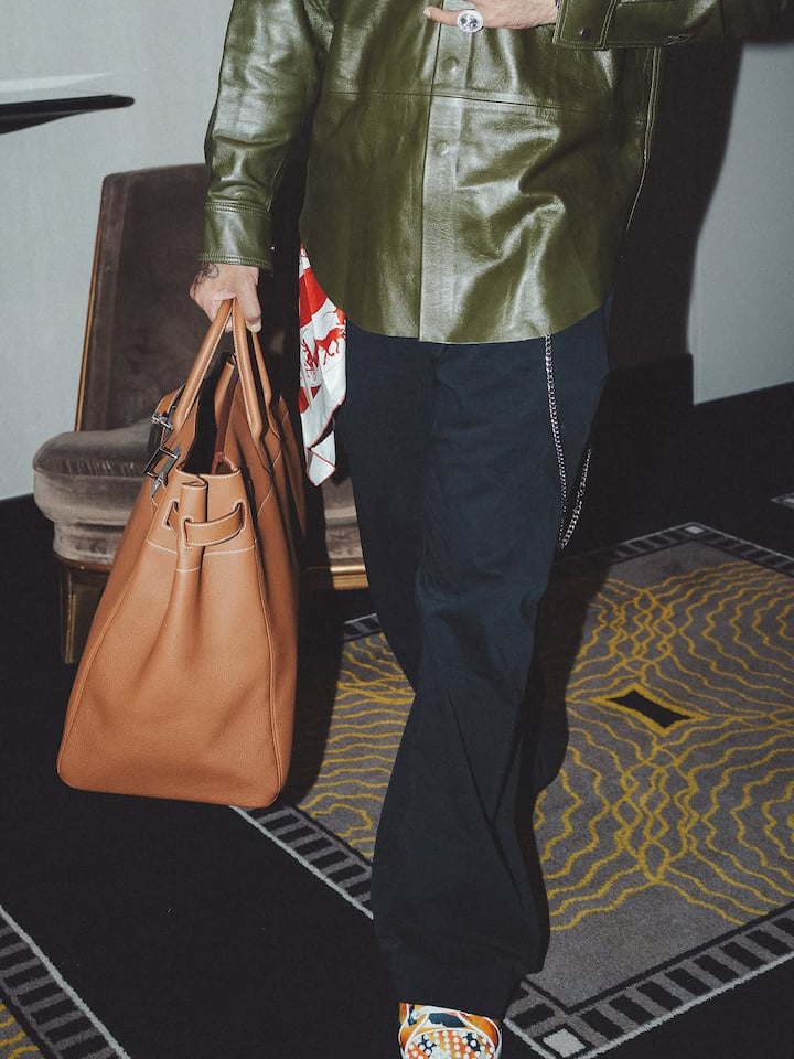 The tan-colored bag with silver accents and white threadwork was the perfect Arm candy for badshah's stylish ensemble.